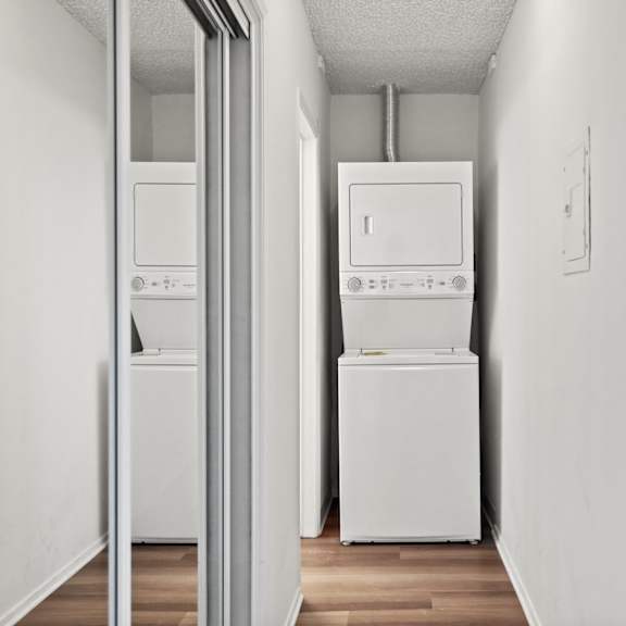 a white wall with a fridge and a washing machine.