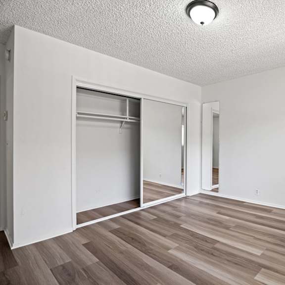 a room with a white wall and a wooden floor.