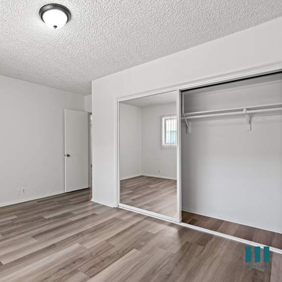 a room with a sliding door and wood flooring.