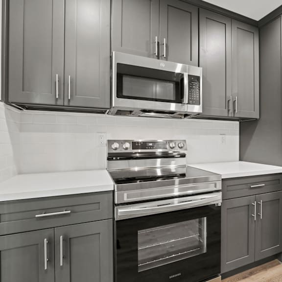 a kitchen with a stove, oven, microwave, and refrigerator.