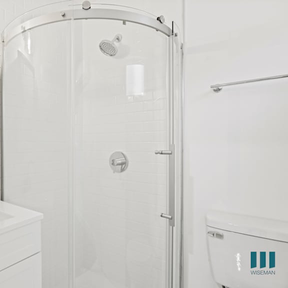 a white bathroom with a sink, shower, and toilet.