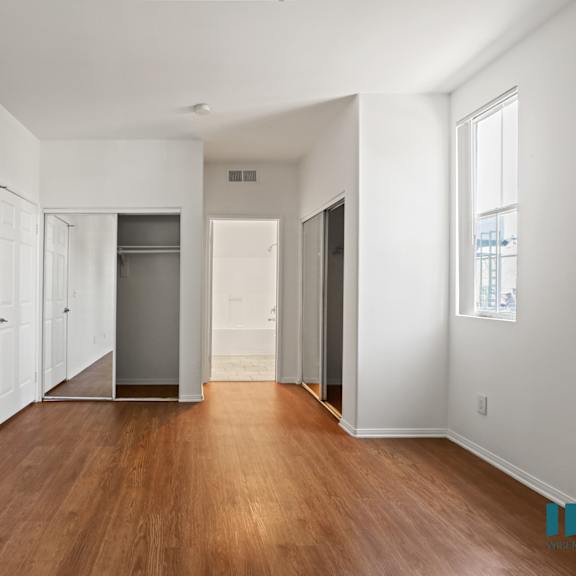 bedroom with  bathroom and double closets