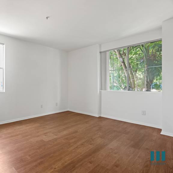 bedroom with large-size windows, mirrored closet, and vinyl flooring