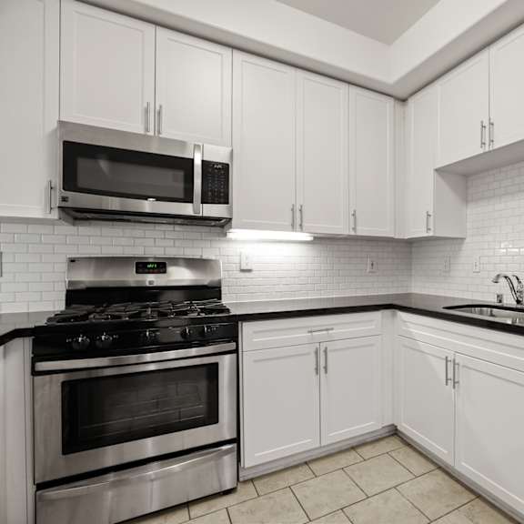 kitchen with stainless-steel stove, microwave oven, dishwasher and countertop bar