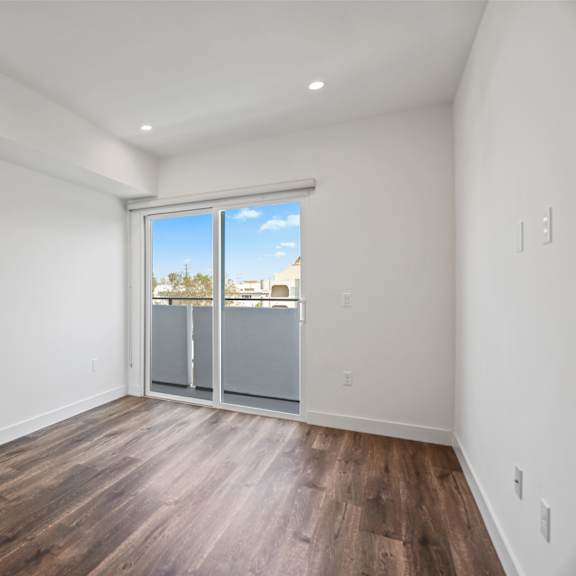 bedroom with recessed lighting, vinyl flooring, and balcony