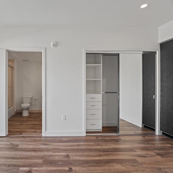 large-size bedroom with vinyl flooring, mirrored closet, and patio