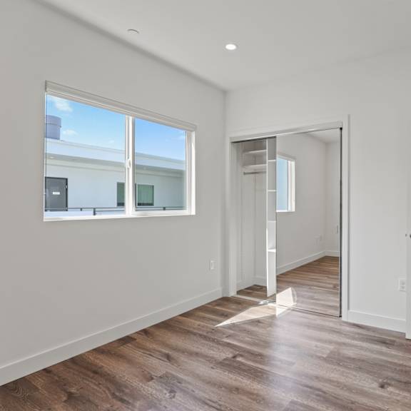 bedroom with mirrored closet, vinyl flooring, and window