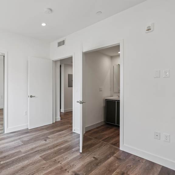 bedroom with mirrored closet with shelving, vinyl flooring, and recessed lighting