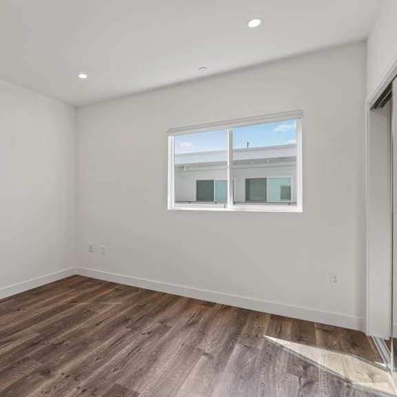 bedroom with recessed lighting, mirrored closet, vinyl flooring, and window