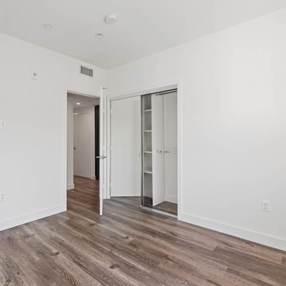 bedroom with mirrored closet and vinyl flooring