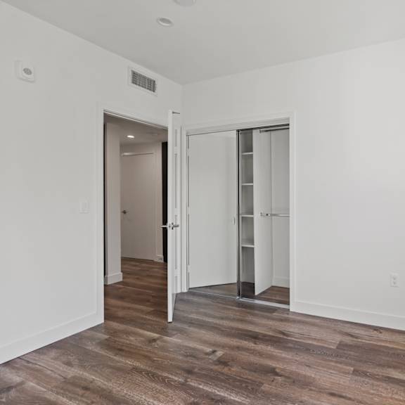 bedroom with vinyl flooring, recessed lighting, closet, and window