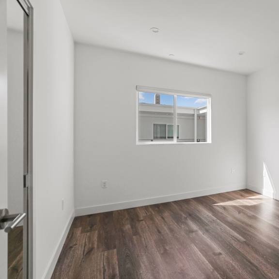 bedroom with mirrored closet, vinyl flooring, and window