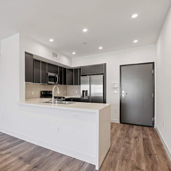 a kitchen with white countertops and black cabinets