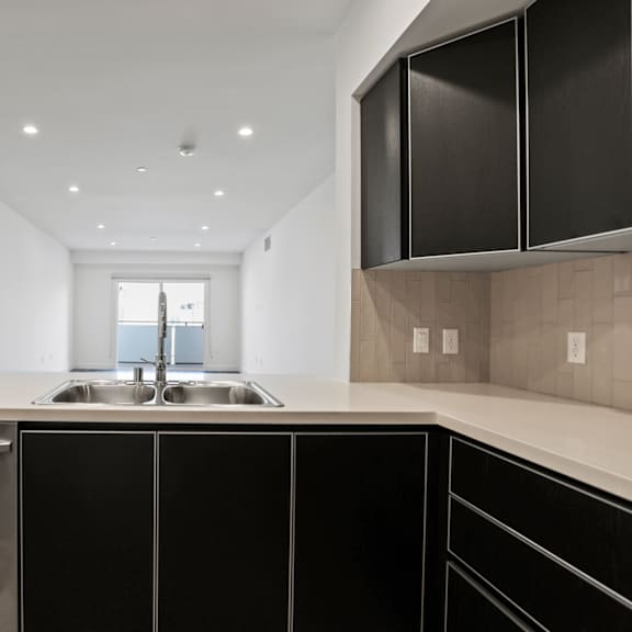 a kitchen with white countertops and black cabinets