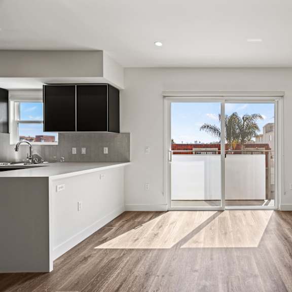 a kitchen with white cabinetry and hardwood floors