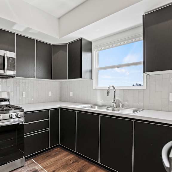 a kitchen with black cabinets and white countertops