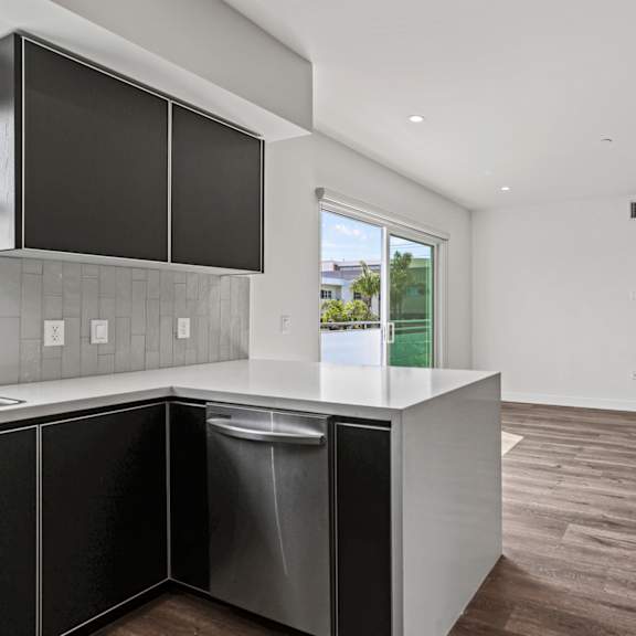 a kitchen with white walls and a wooden floor