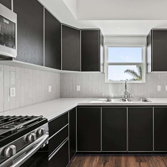 a kitchen with black cabinets and white countertops