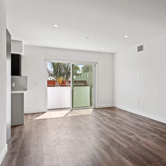 a bedroom with hardwood floors and white walls