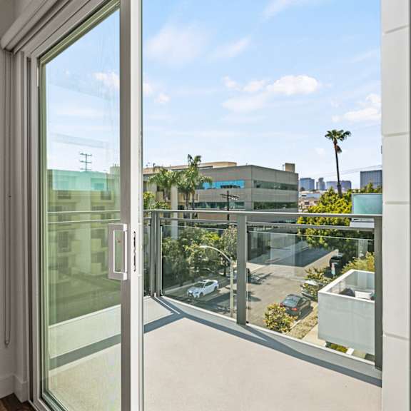 a bedroom with a large window and a balcony