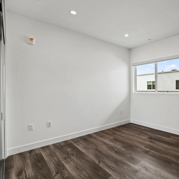 a bedroom with white walls and a window