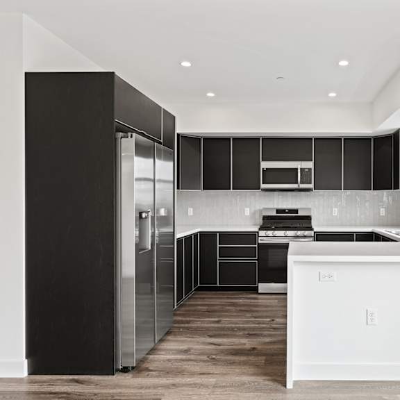 a kitchen with white countertops and black cabinets