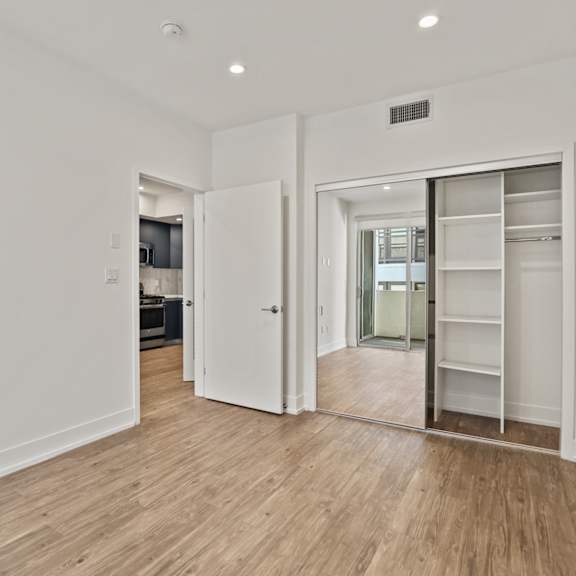 bedroom with closet with built-in shelving, vinyl flooring, and recessed lighting