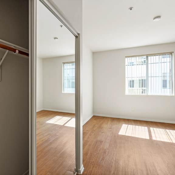 bedroom with large closet, vinyl flooring, and large-size window