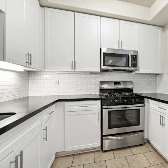 kitchen with stone countertops, stainless-steel appliances, and ample cabinet storage