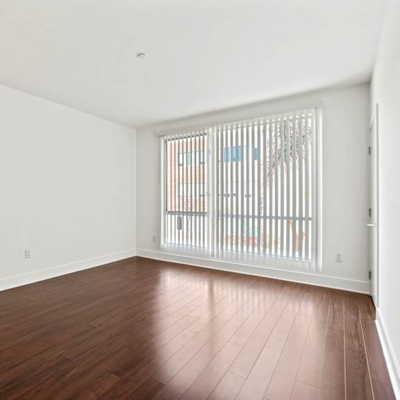 bedroom with vinyl flooring and large windows