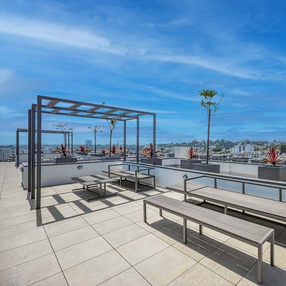 a rooftop patio with a table and chairs.