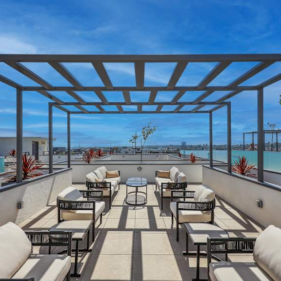 a rooftop patio with a pool and lounge chairs.