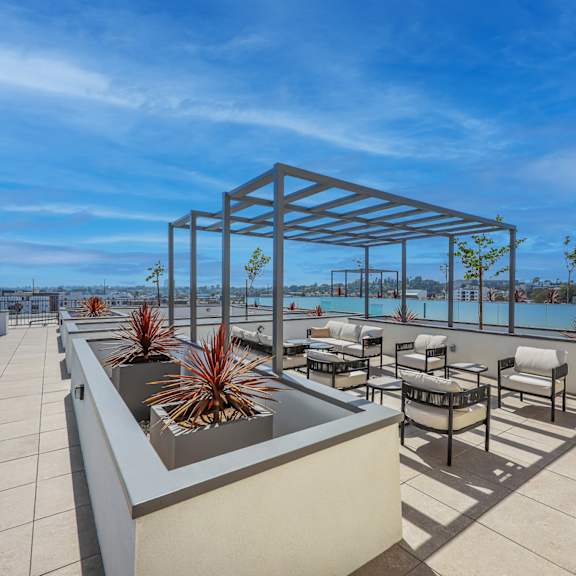 a rooftop patio with a table and chairs.