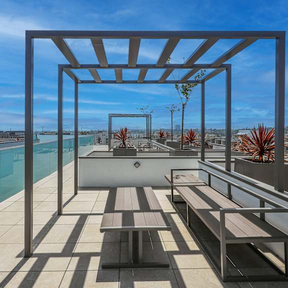 a patio with a table and chairs overlooking a pool.