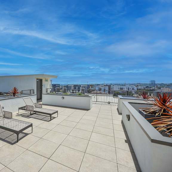 a patio with a table and chairs overlooking a cityscape.