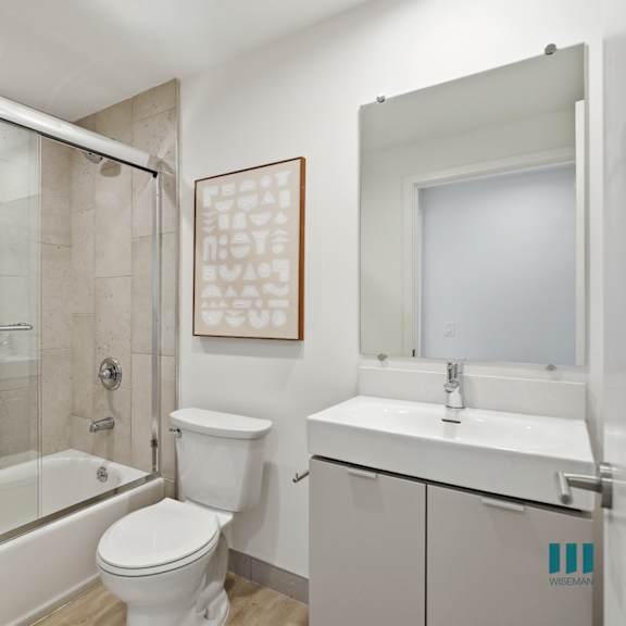 a white towel hangs on a glass shower door.