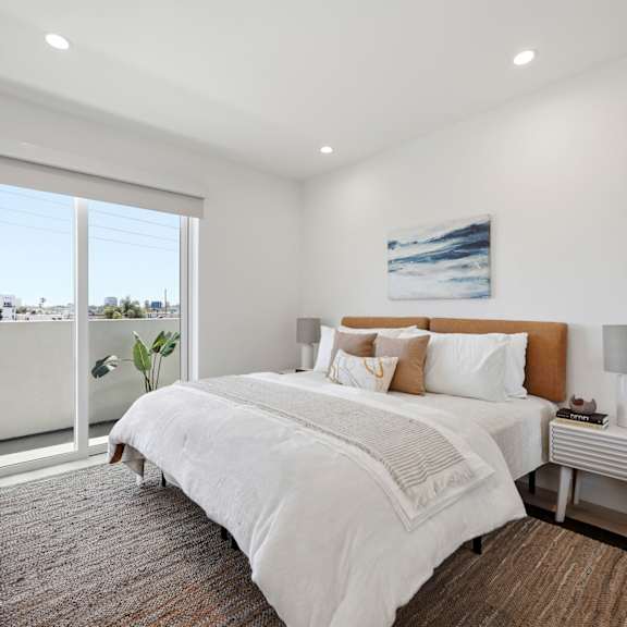 a bedroom with a large bed and a view of the outside.
