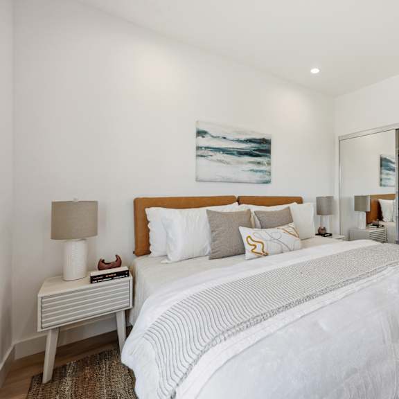 a bedroom with a large bed and a painting on the wall.