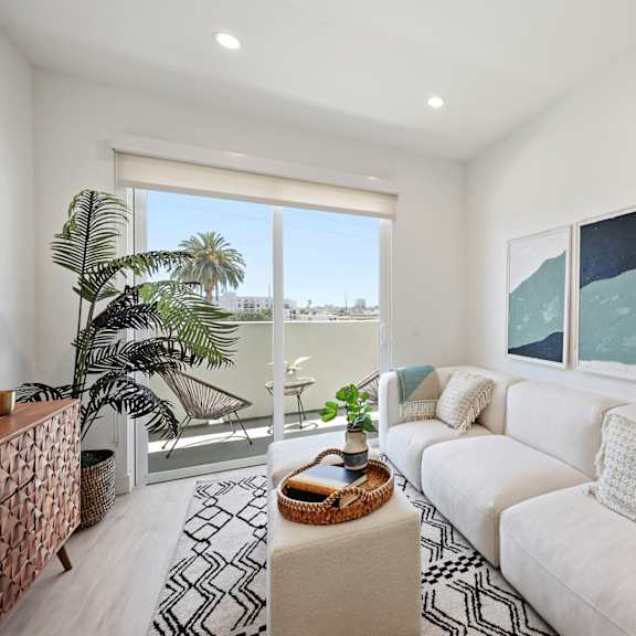 a living room with a white couch and a painting on the wall.