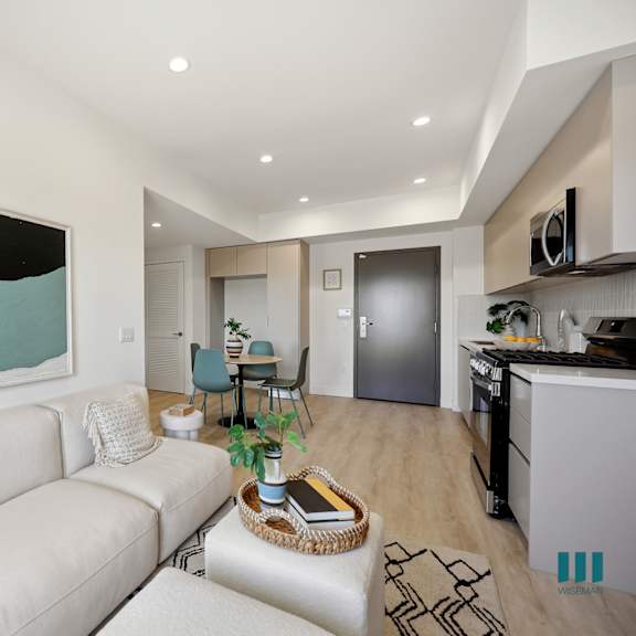 a modern living room with a white couch and a painting on the wall.