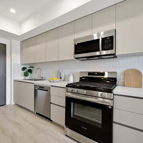 a modern kitchen with a black fridge, stove, and microwave.