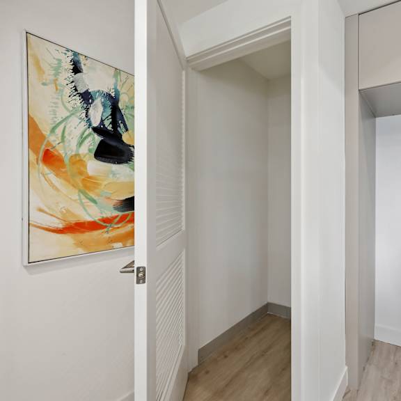 a hallway with a painting on the wall and a white door.