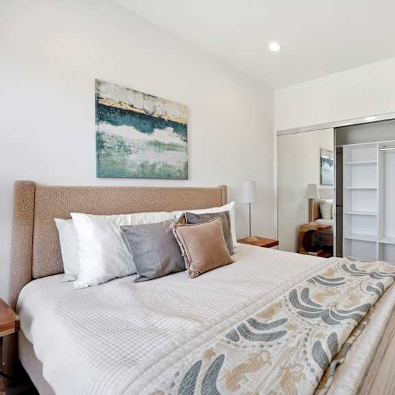 a bedroom with a large bed and a painting on the wall.