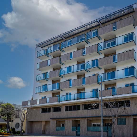 a tall building with balconies and a sign that reads "3657" on the front.