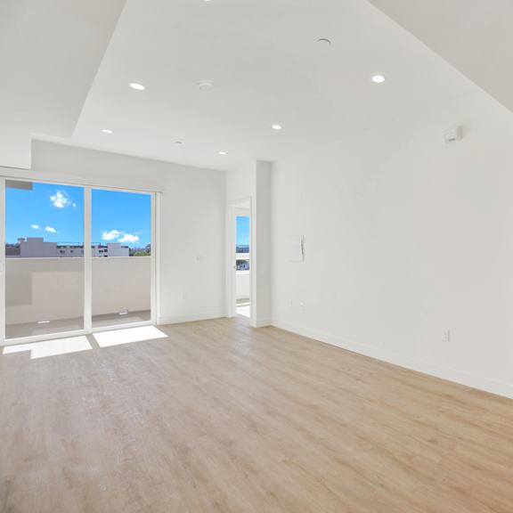 a spacious, empty room with wooden floors and white walls.