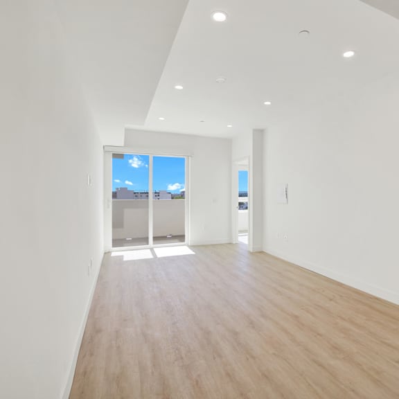 a long, empty room with a view of the sky through a window.