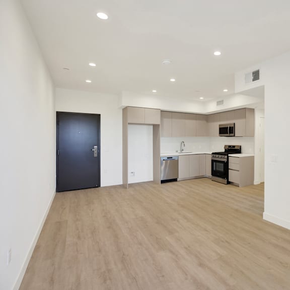 a spacious room with a kitchen area and a refrigerator.