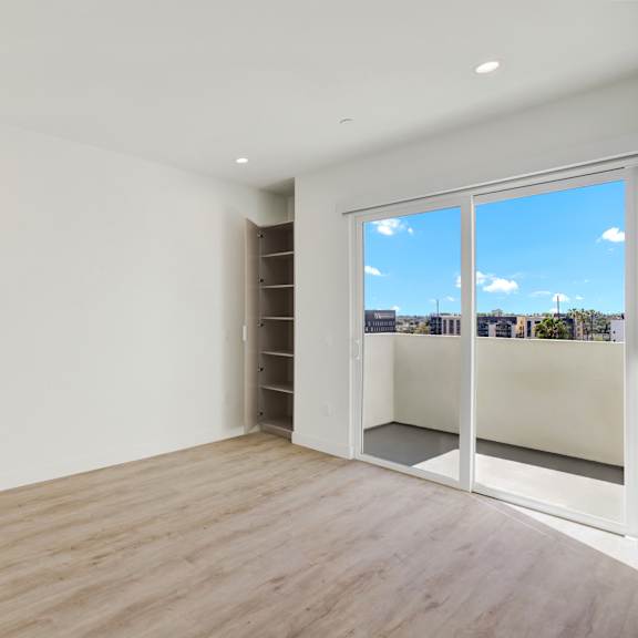 a room with a sliding glass door leading to a balcony.
