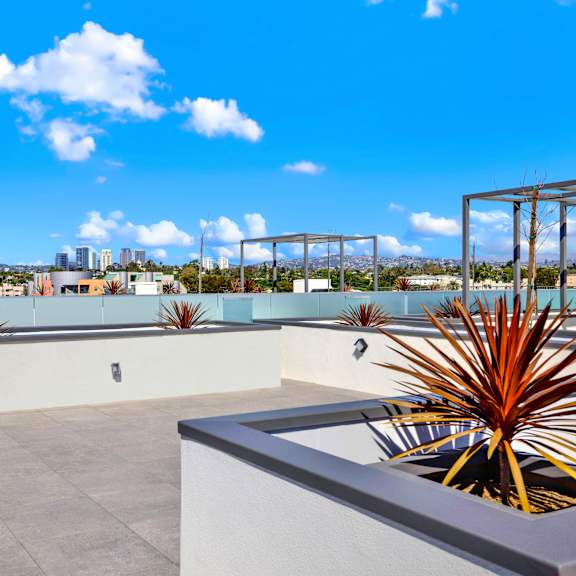 a rooftop patio with a concrete floor and white walls.
