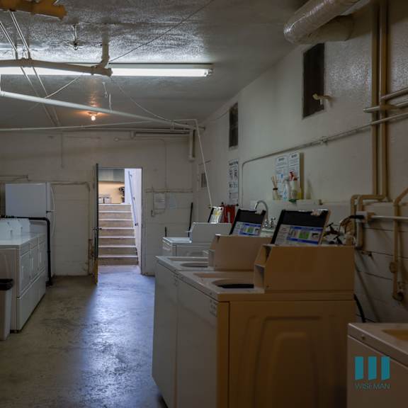 a dirty industrial kitchen with lots of white appliances.